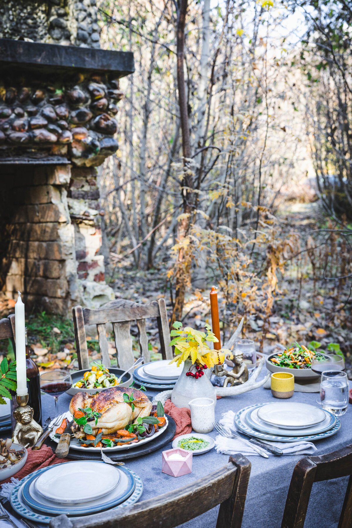 Outdoor dinner party in woods.    Fall thanksgiving dinner party.