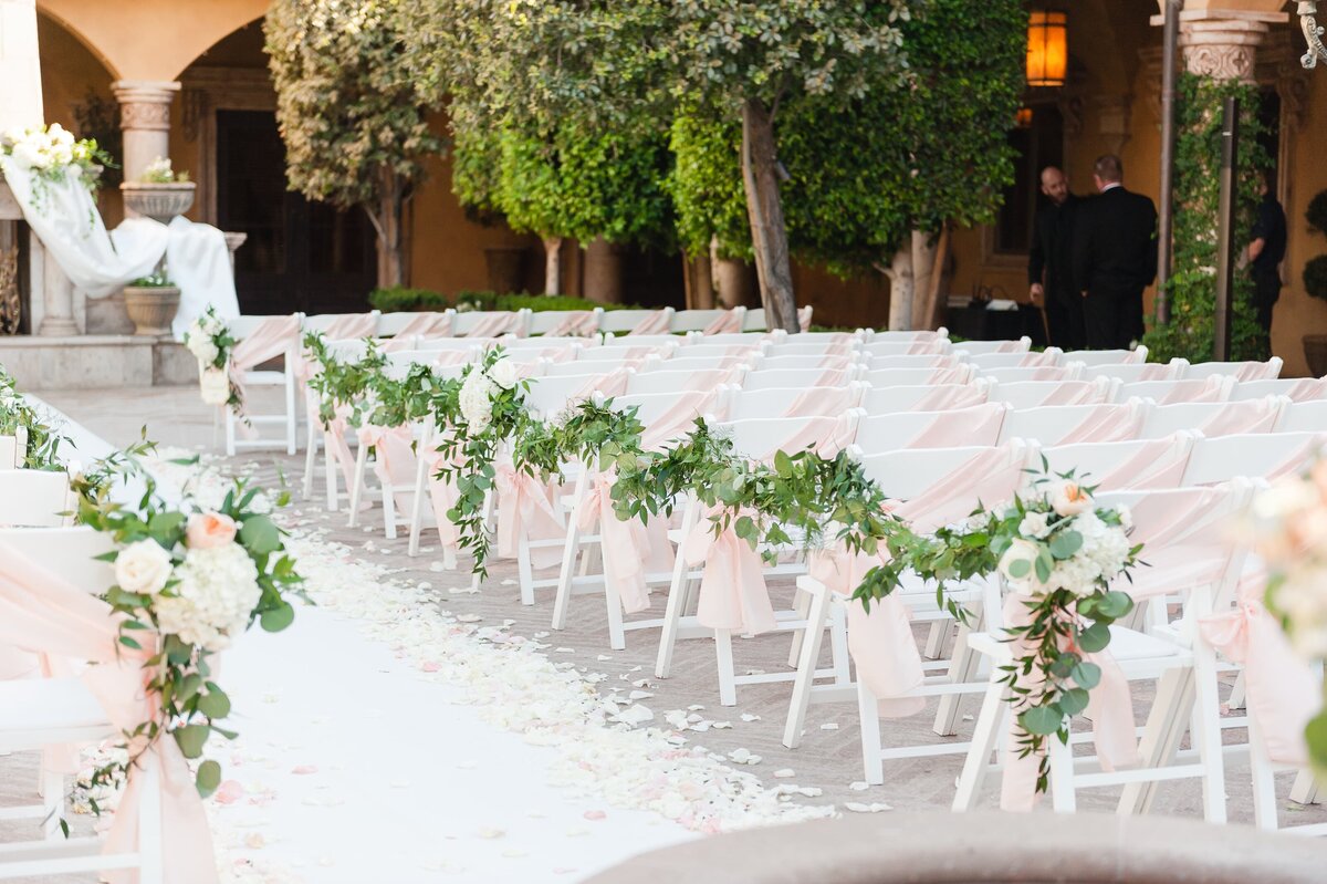 ceremony-setting-with-blush-chair-sashes-and-greenery
