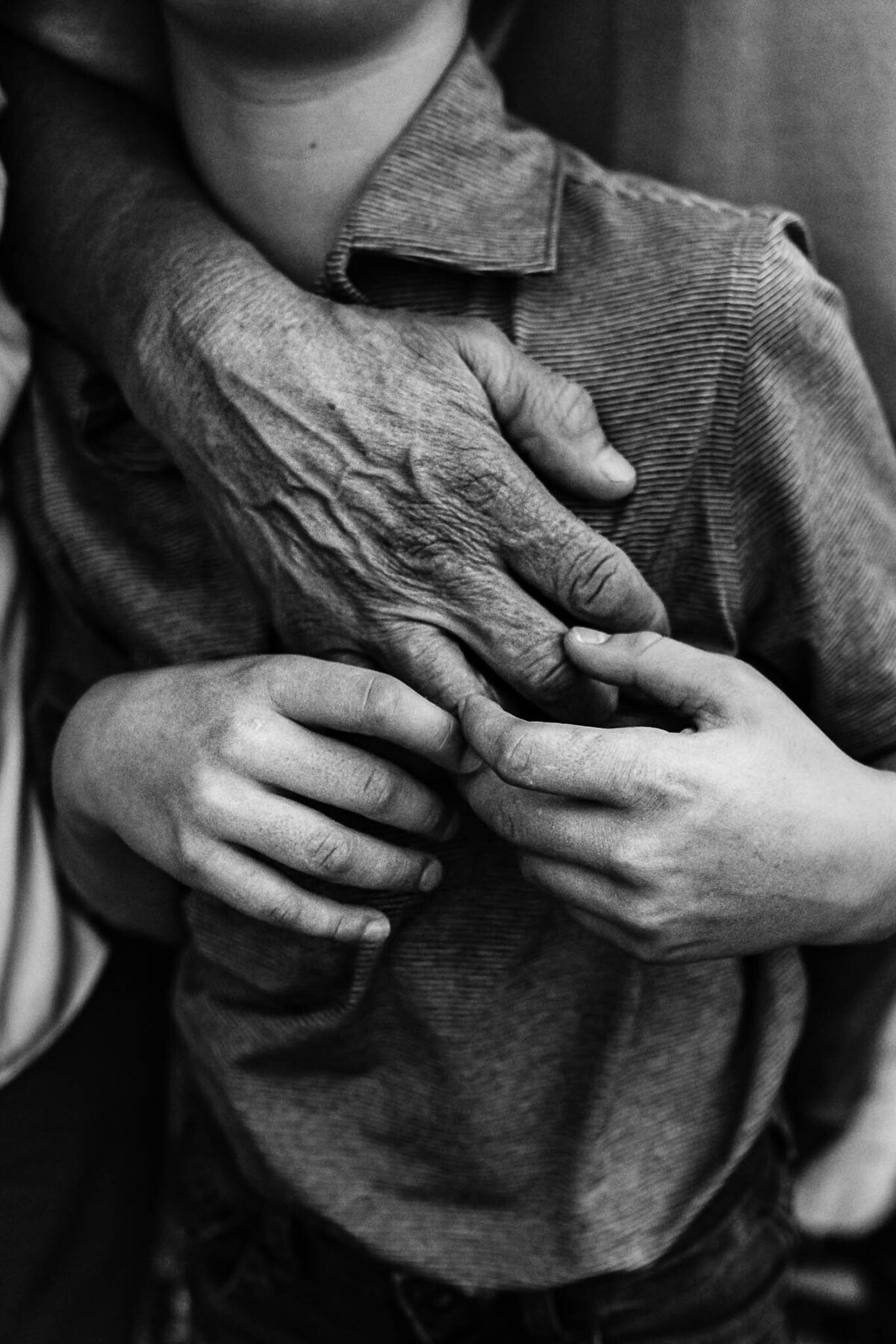 black and white image of child and grandpa hands