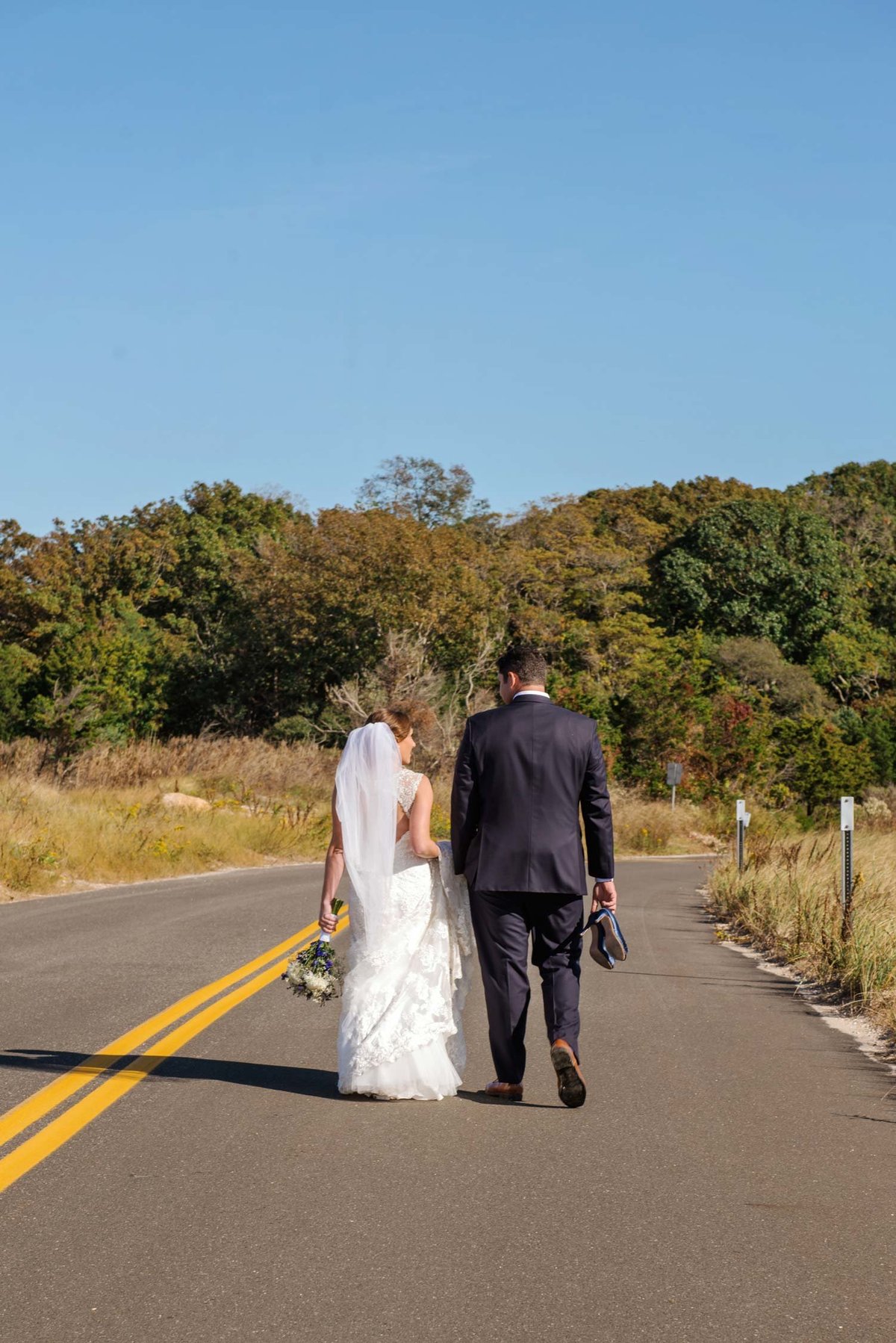Bride and groom walking down the road at The Ram's Head Inn