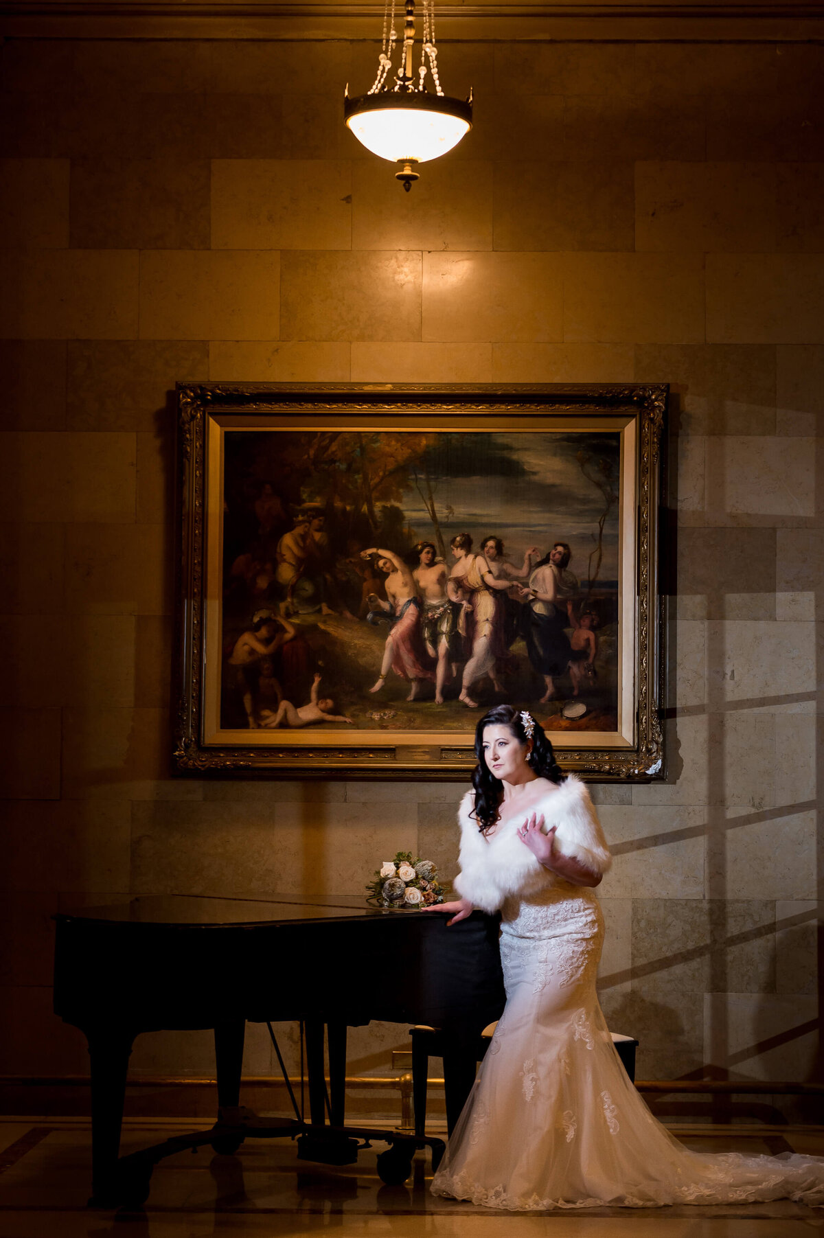 Ottawa wedding photography of an elegant bride leaning on the grand piano inside the Chateau Laurier hotel