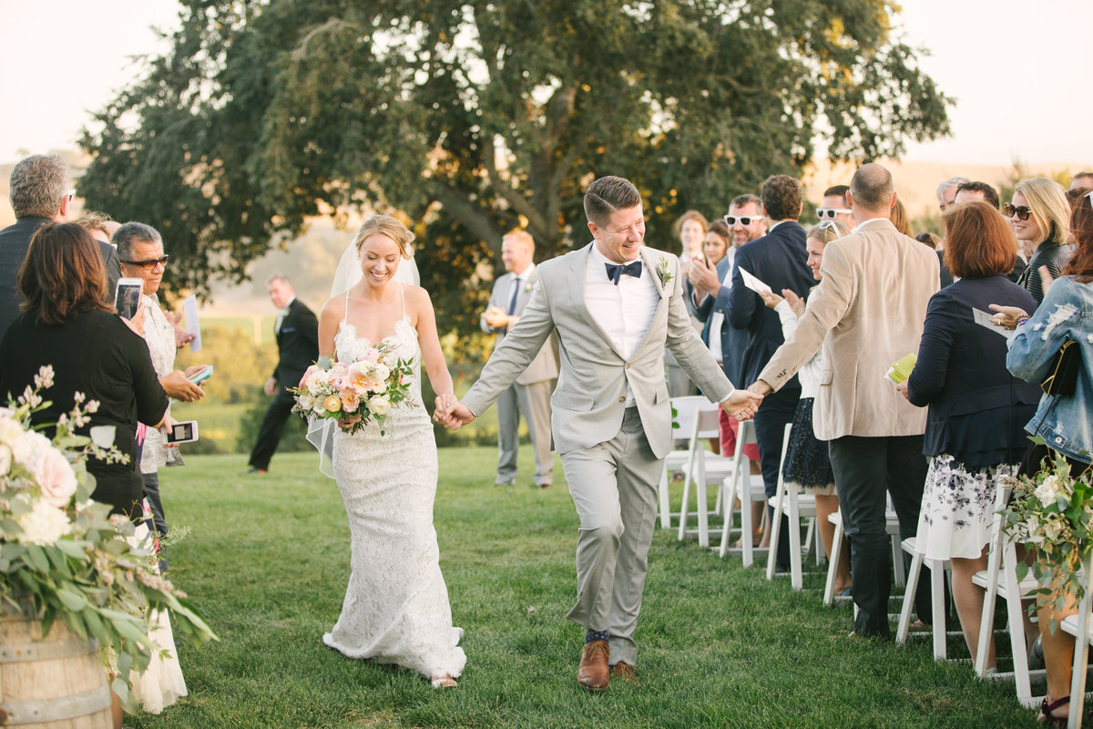 Bride and groom walk down aisle after ceremony at Firestone Vineyard