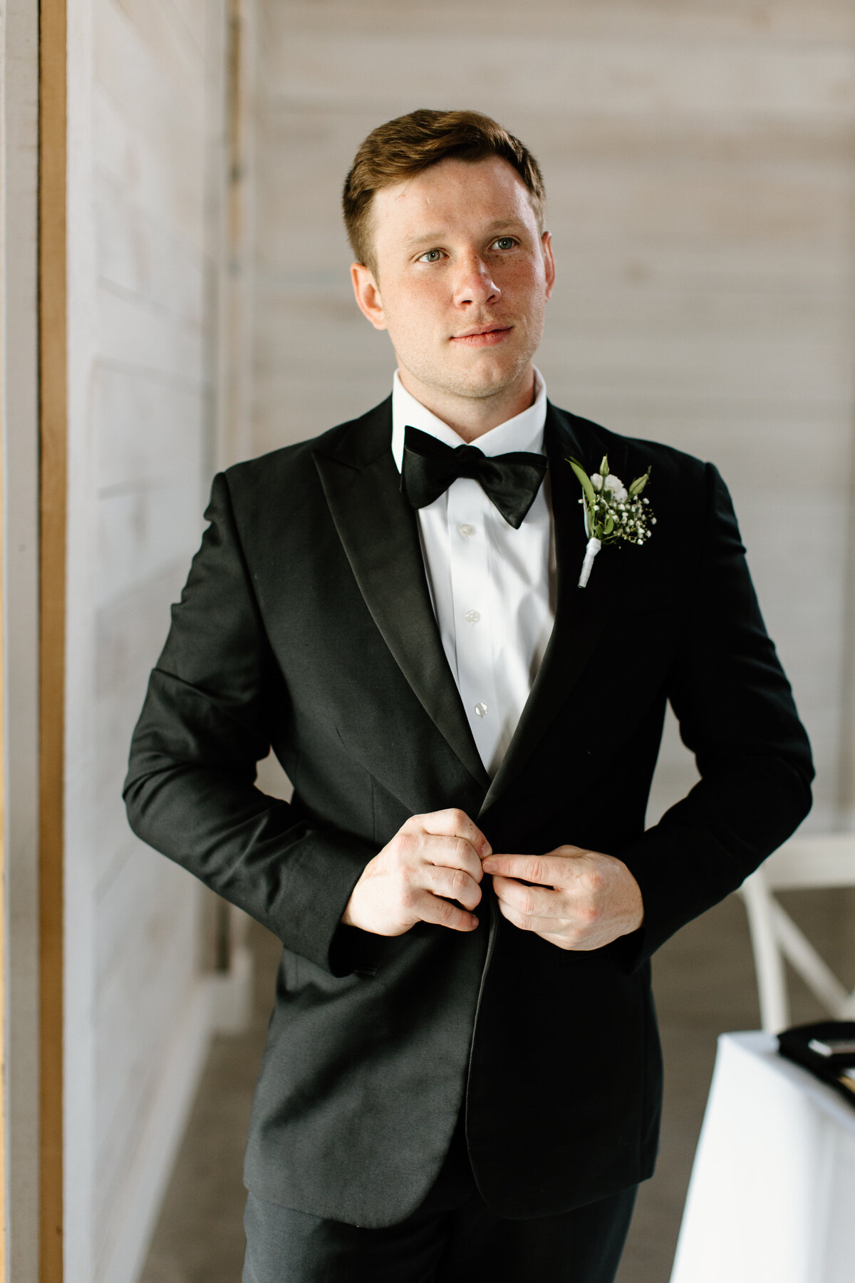 Groom wearing black and white tux with bowtie