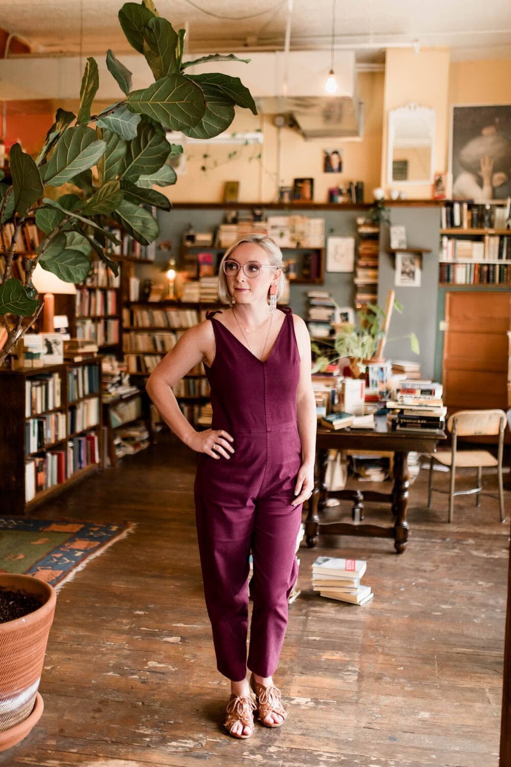 crystal genes photography stands in Mother Foucault's bookshop wearing a burgundy jumpsuit