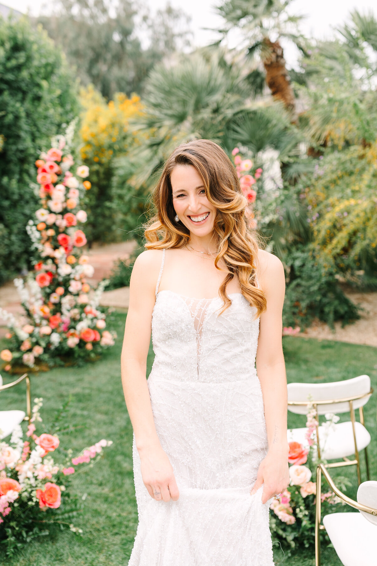 bride smiling in front of floral ceremony arch in outdoors napa wedding venue.