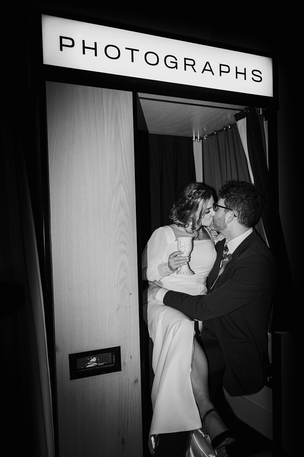 Bride and groom kiss in photo booth at Greenhouse Loft in Chicago, il