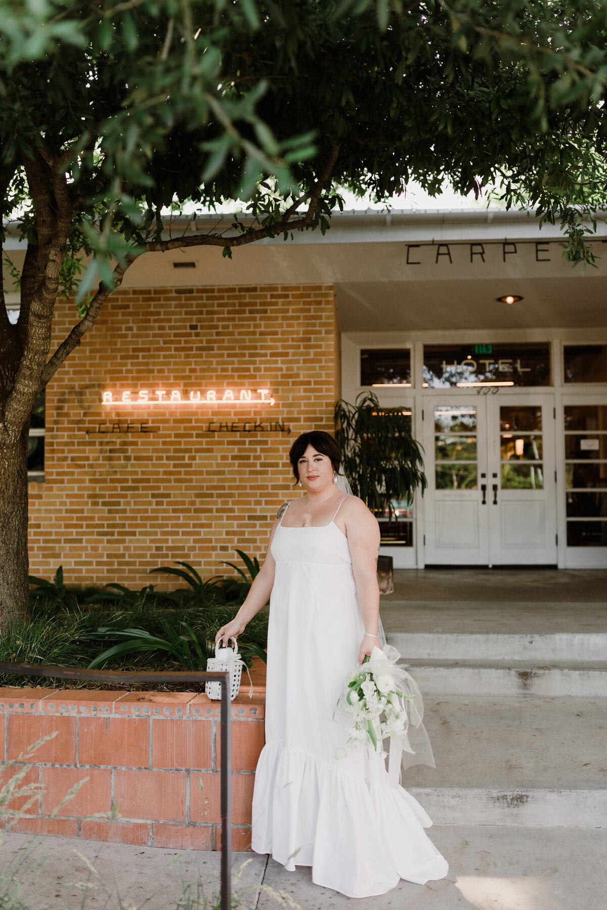 Bride standing outside the entrance  to the Bride and groom portraits at  Carpenter Hotel, Austin