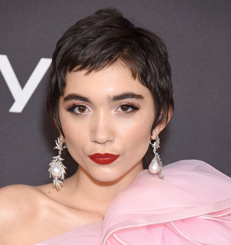 Rowan Blanchard with a pixie haircut in a pink dress and red lipstick