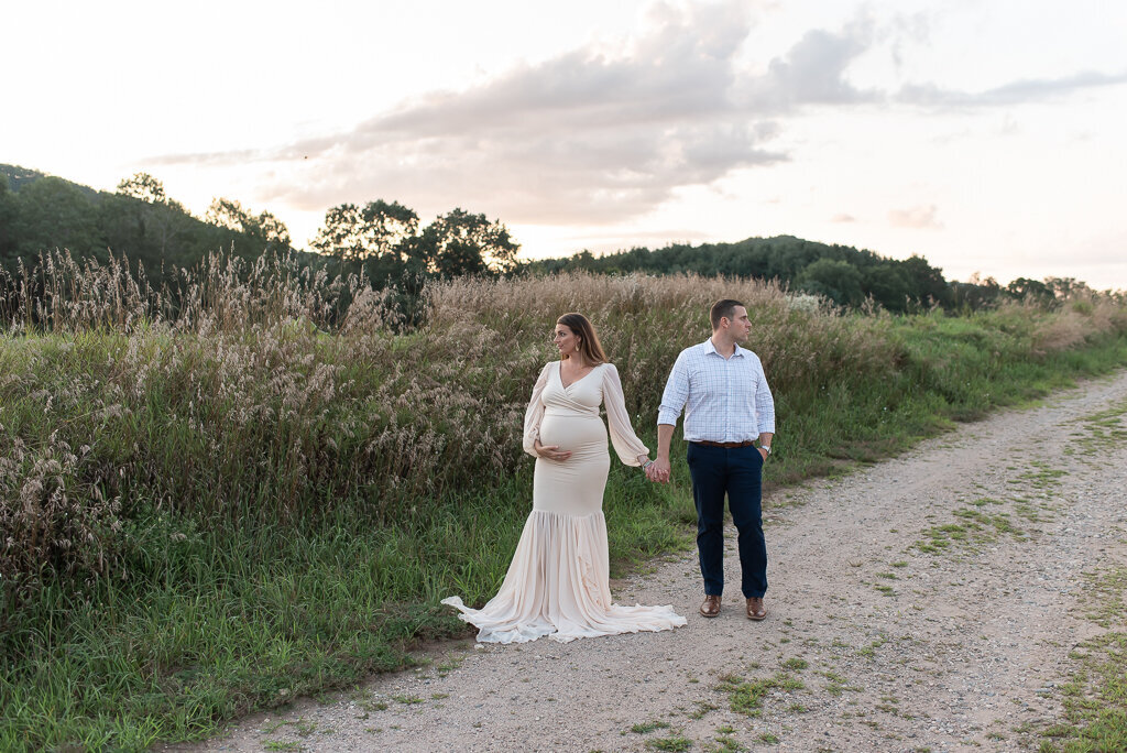 Couple looking in opposite directions, holding hands in field at sunset | Sharon Leger Photography | CT Newborn & Family Photographer | Canton, Connecticut