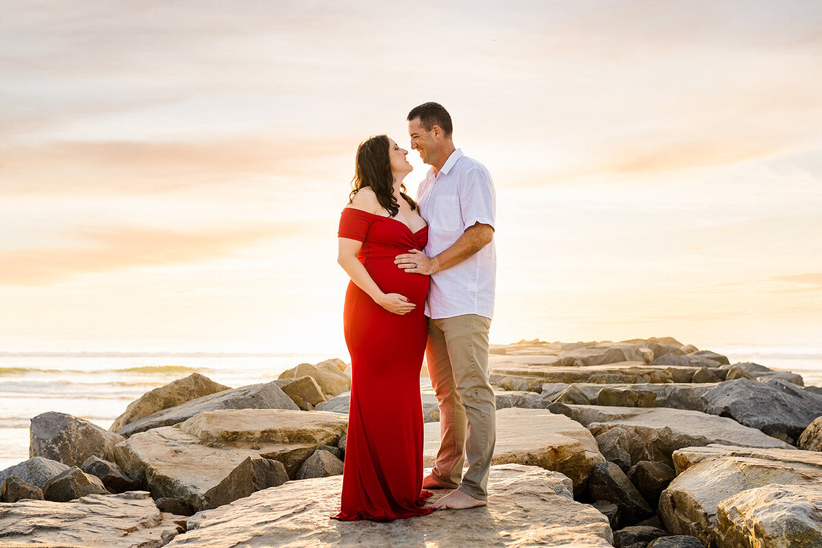 Couple posing for a maternity portrait in Carlsbad