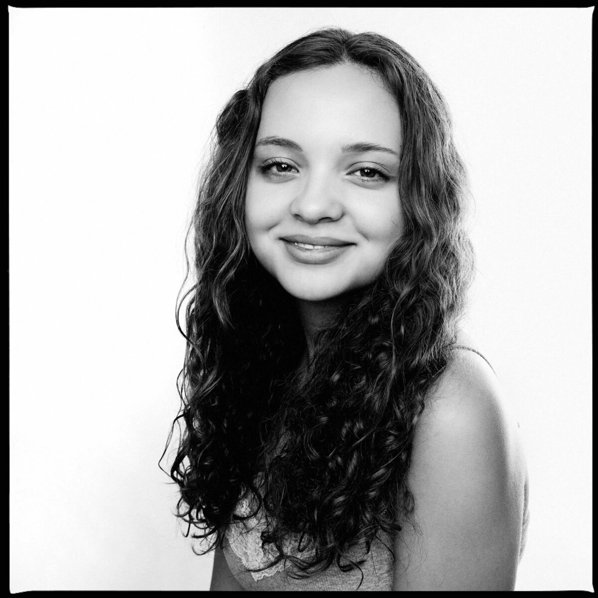 Black and white photo of a teenage girl smiling.