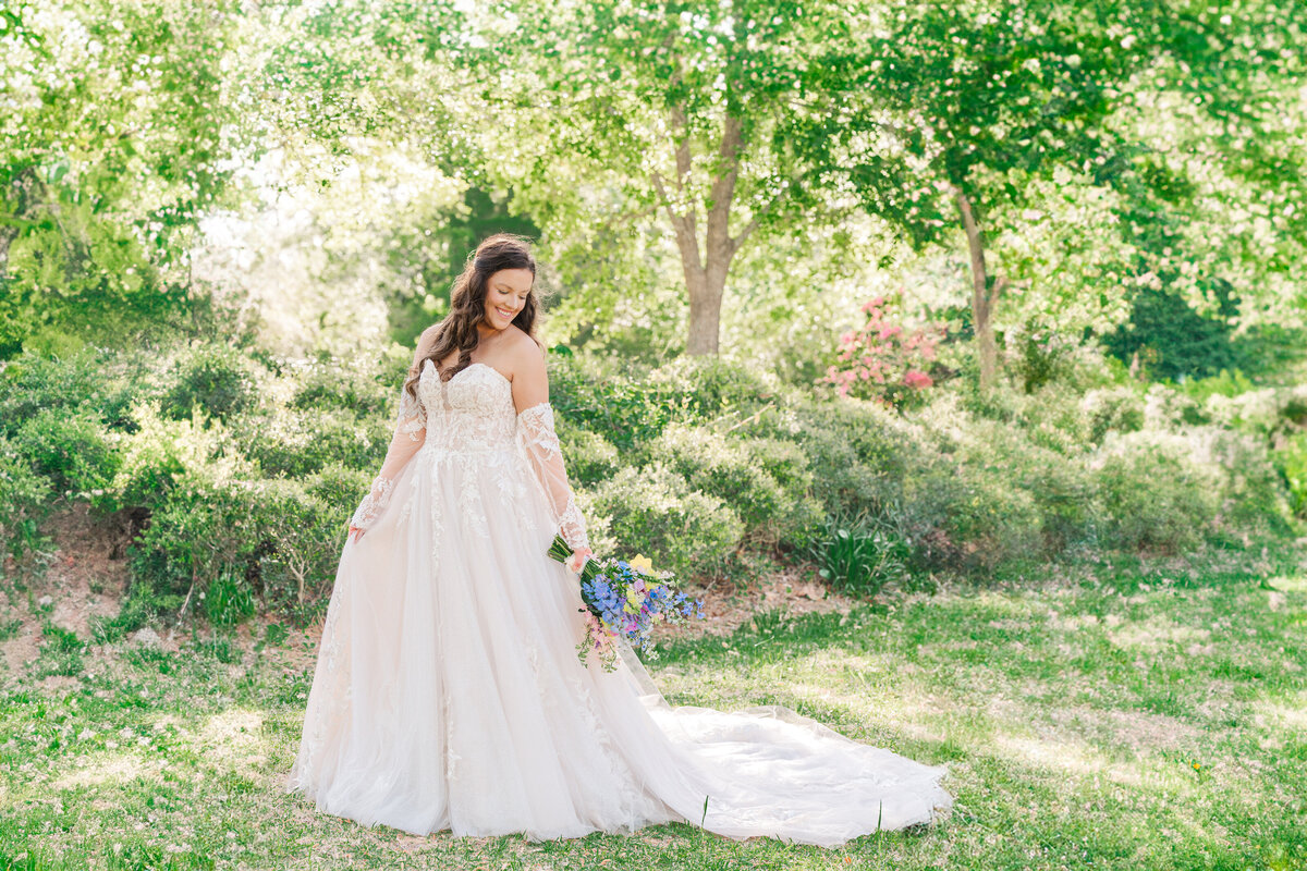 A blushing bride during her bridal session at Duke Gardens in the summer enjoying her Raleigh wedding photography session with JoLynn Photography