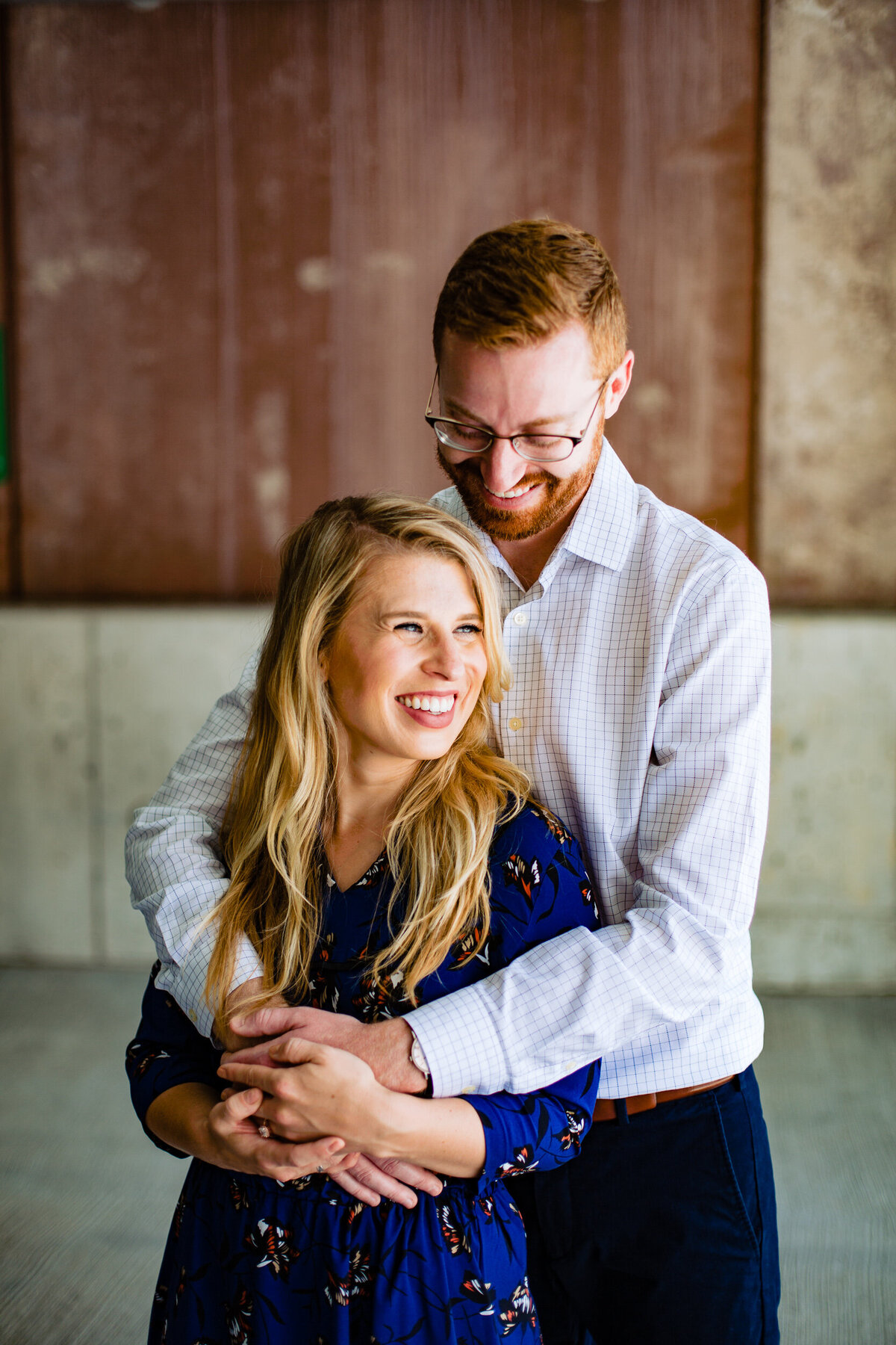 An engagement photo in Toledo Ohio as a couple giggles in the city.  Photo By Adore Wedding Photography. Toledo Wedding Photographers