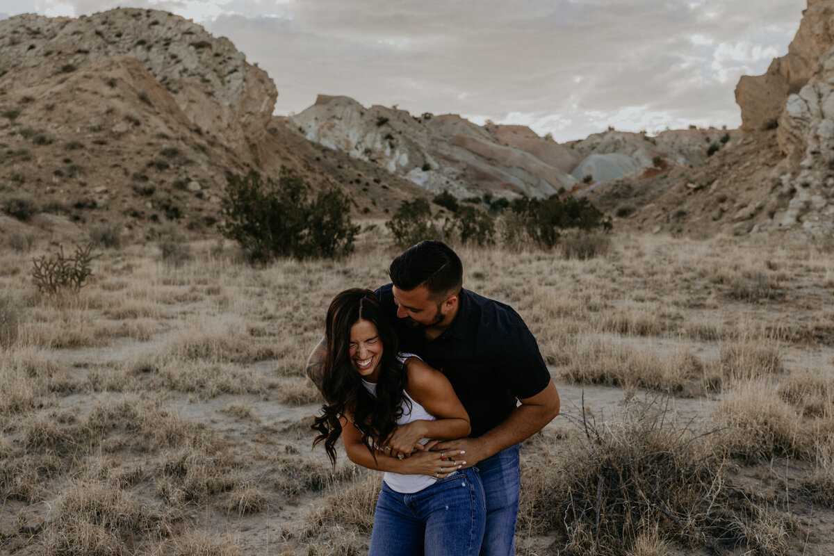 engaged couple hugging and being silly in the desert