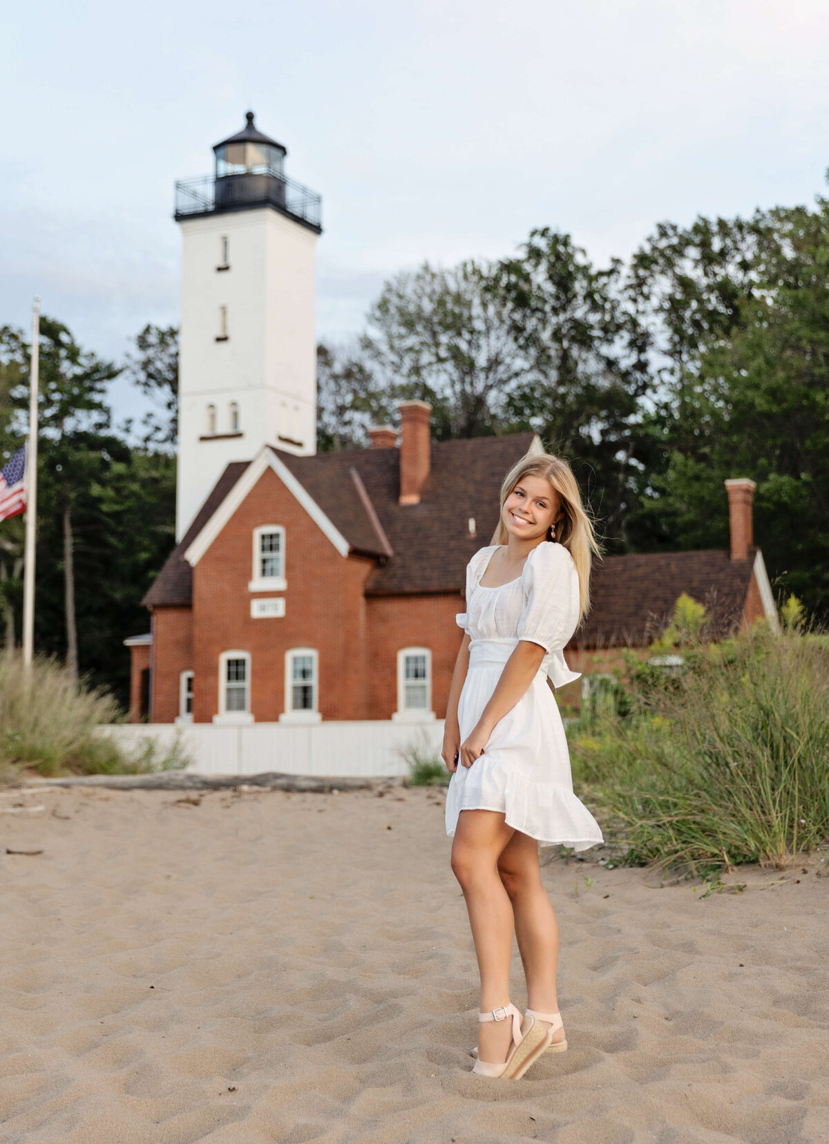 Senior portrait of girl standing in from the one of the Presque Isle lighthouses on an Erie Pa beach
