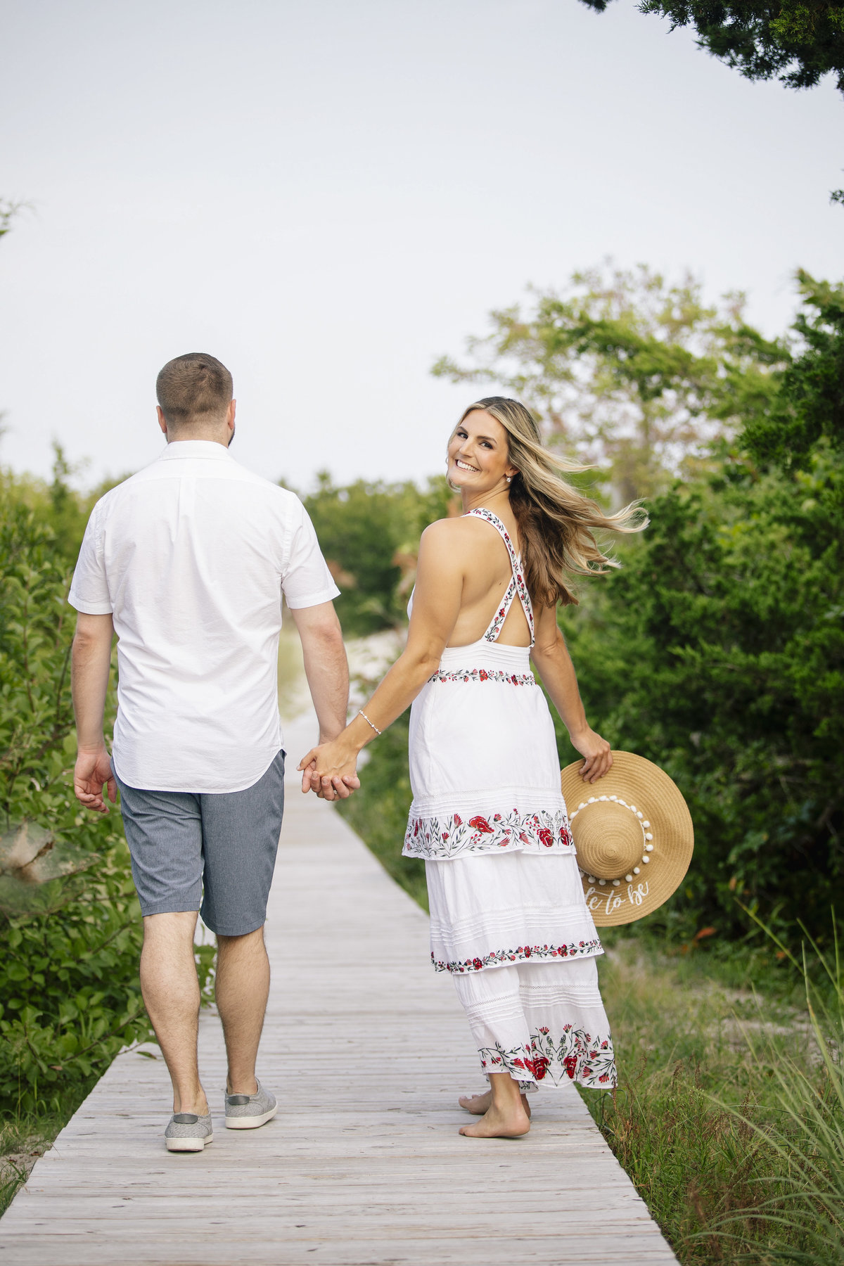 engaged couple walk on path at LBI session
