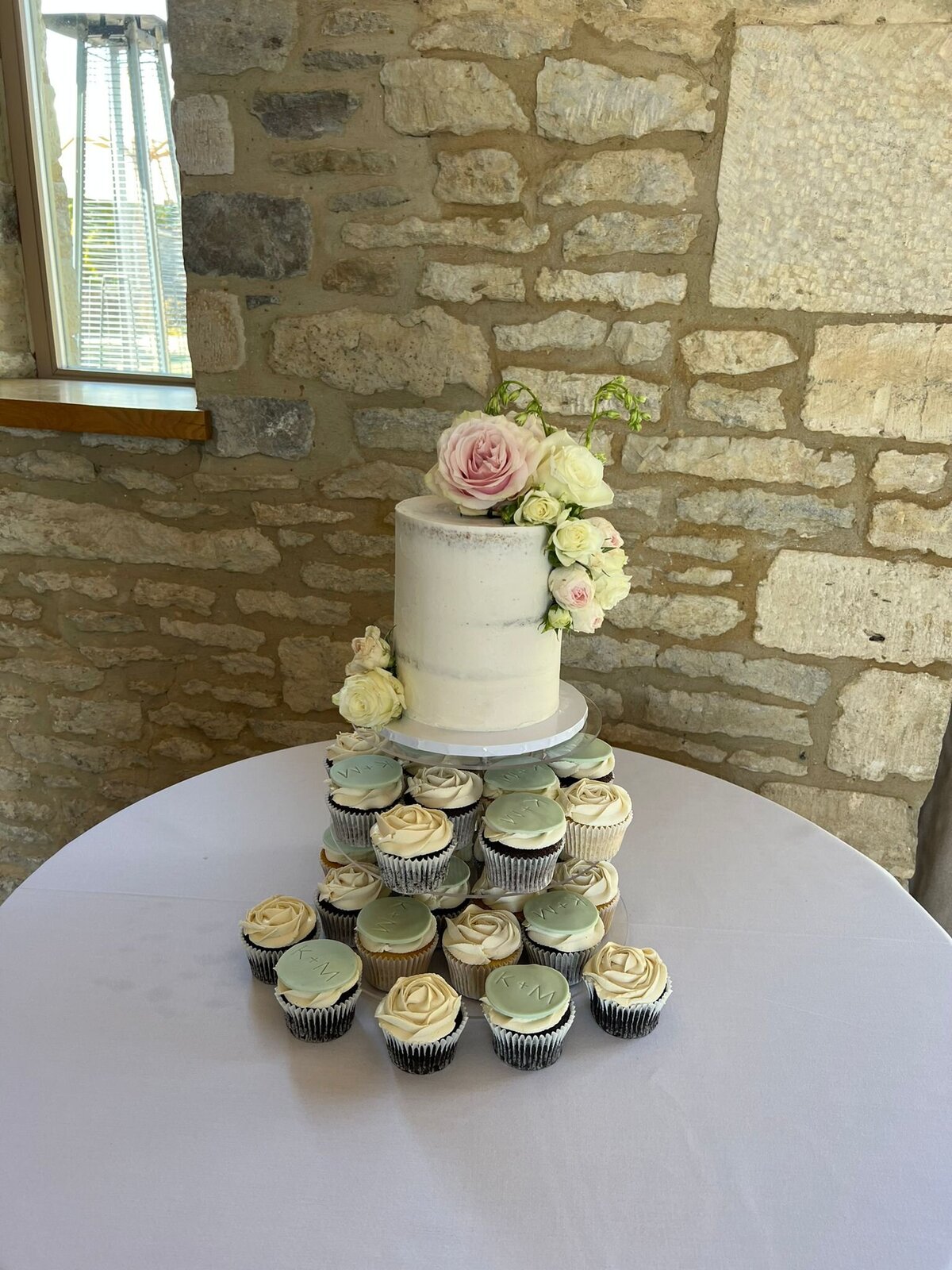 Single tier semi-naked wedding cake with cupcake tower