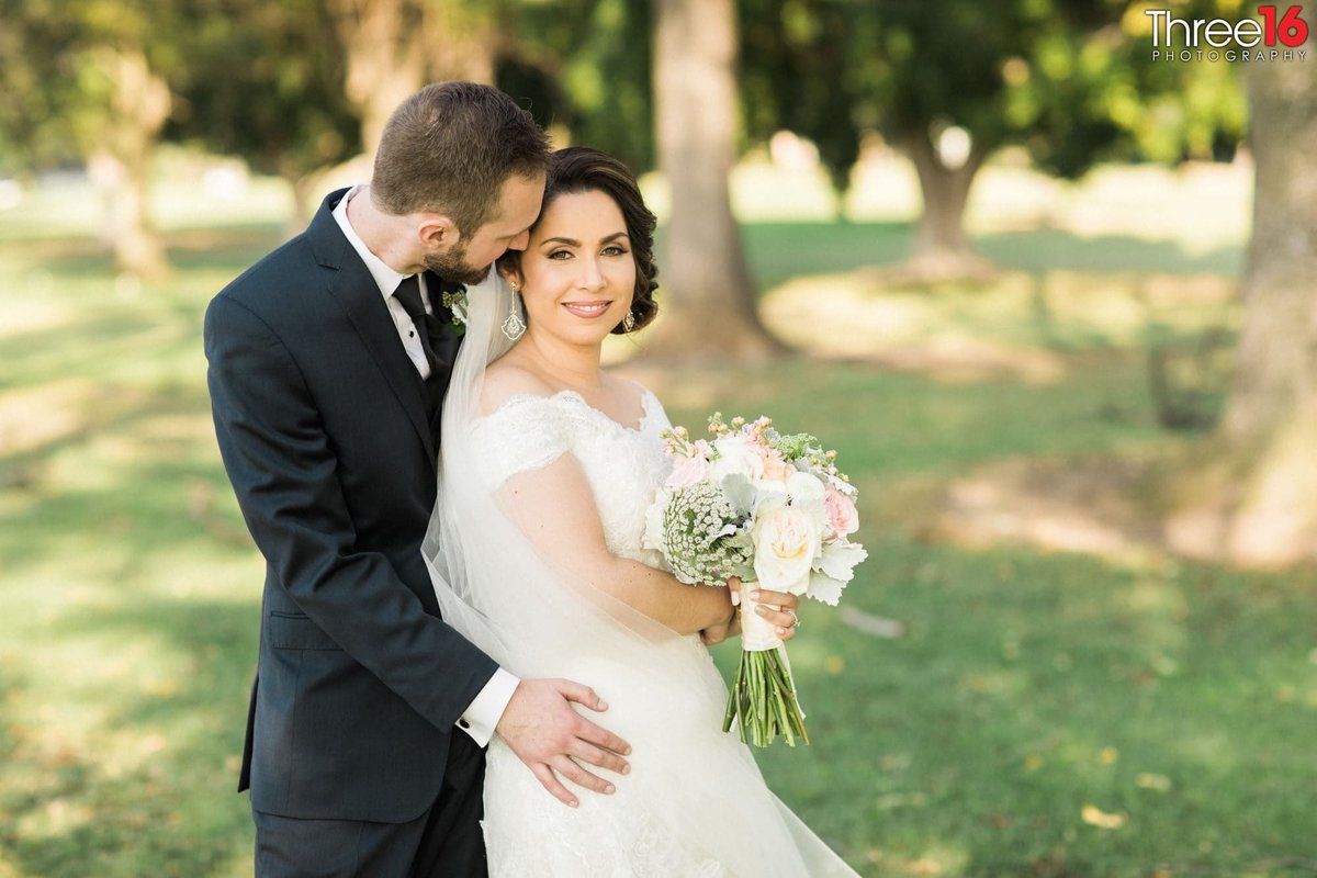 Groom whispers to his smiling Bride during the photo shoot
