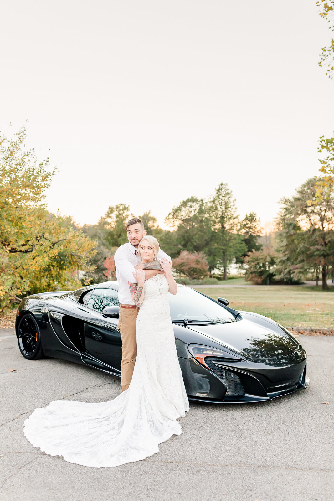 bride and groom leaning on their car