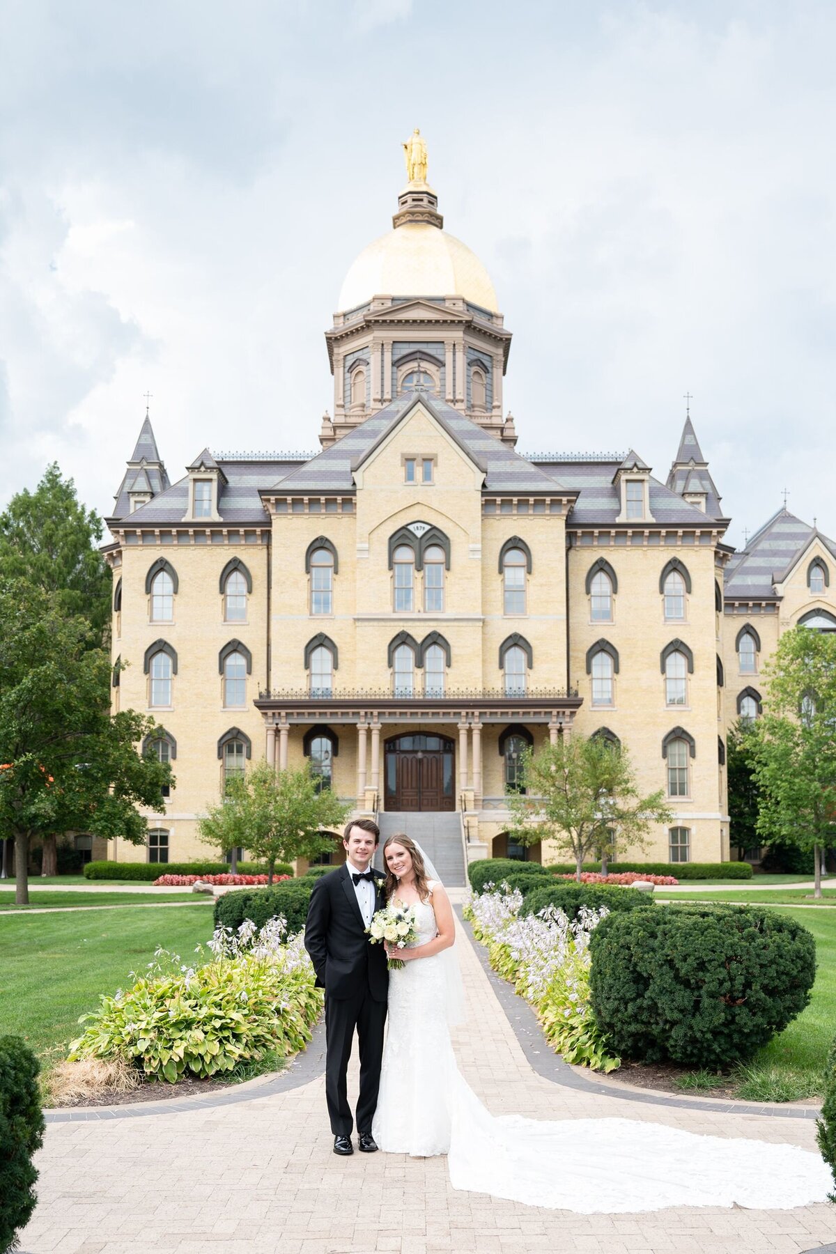 Bride and groom in front of Notre Dame main building dome