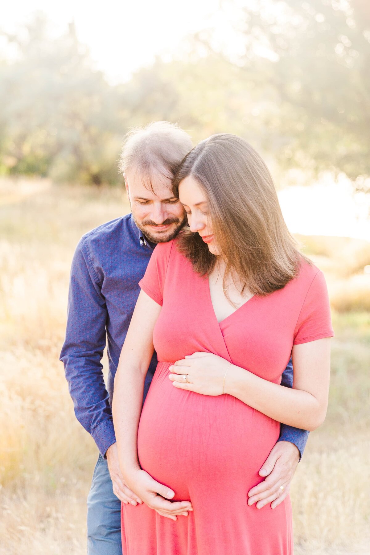 Glowy sunlight wraps around parents during maternity photo shoot