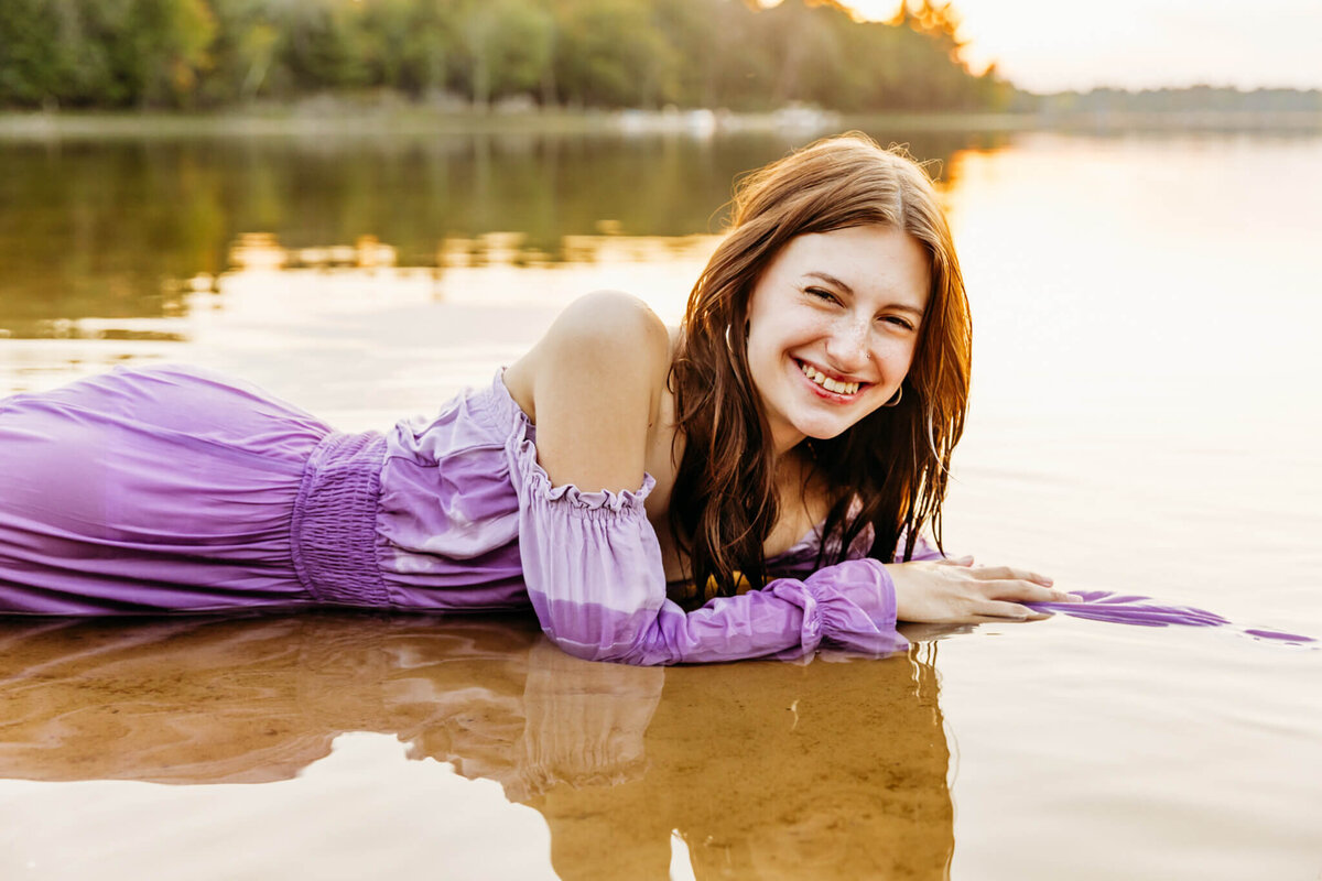 senior girl laying down in the lake for gorgeous senior photos