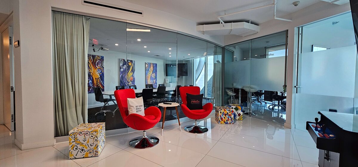2 Red office chairs in front of glass office
