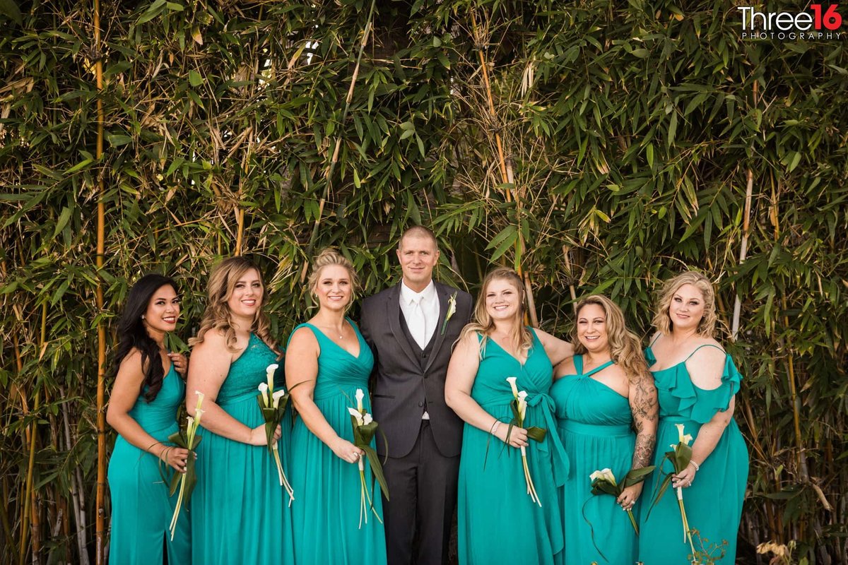 Groom posing with the Bridesmaids
