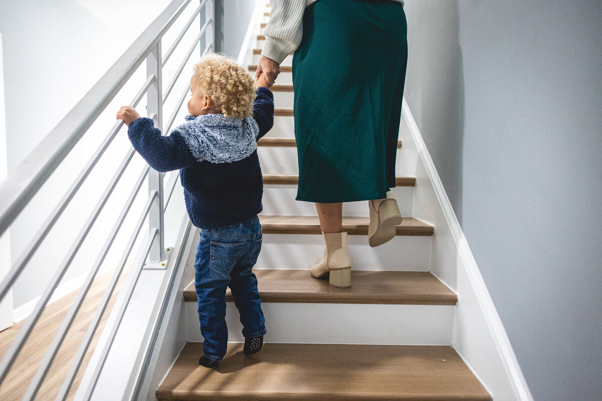 Mother and son hand in hand climbing stairs