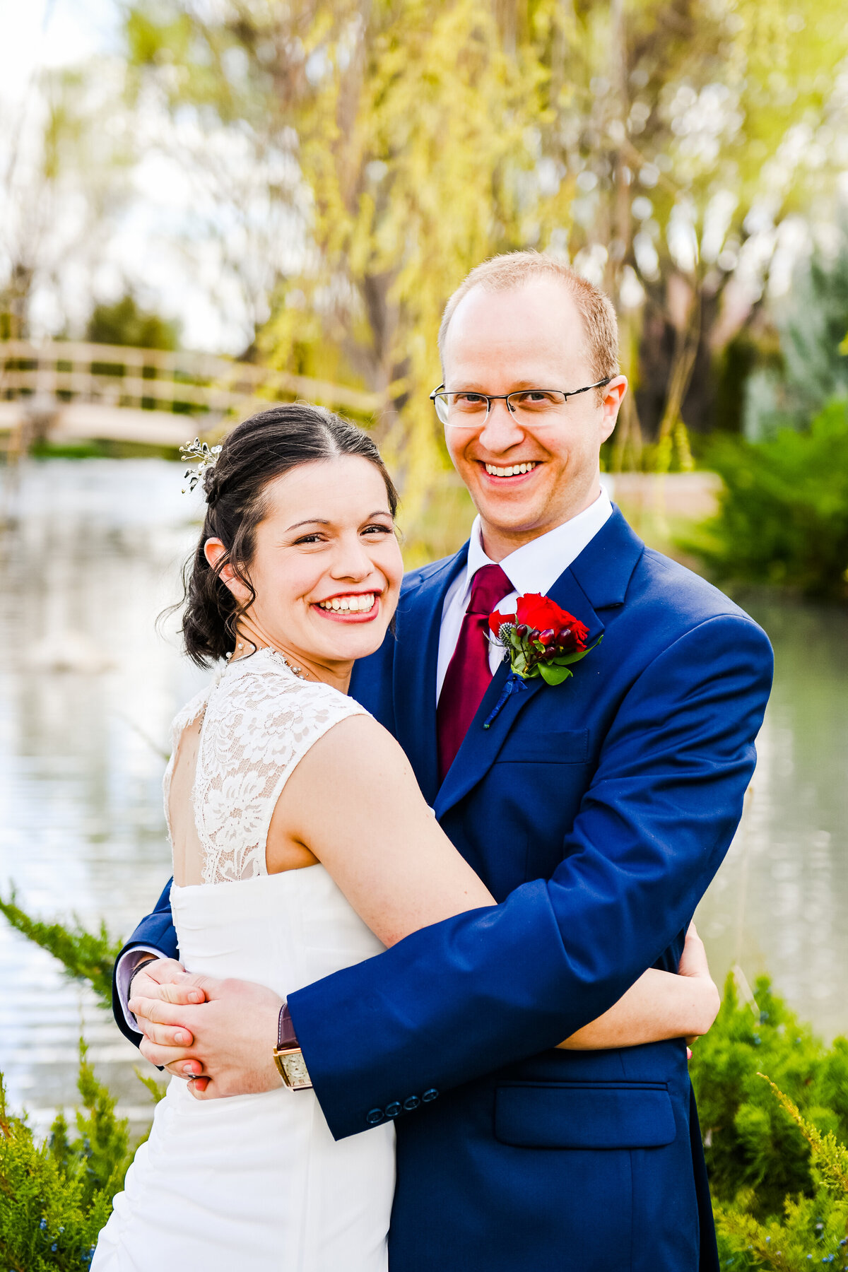 Bride and groom hugging smiling at camera at Windmill House Chino Valley wedding lake water