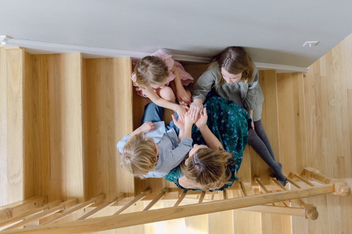 mom playing with kids on stairs