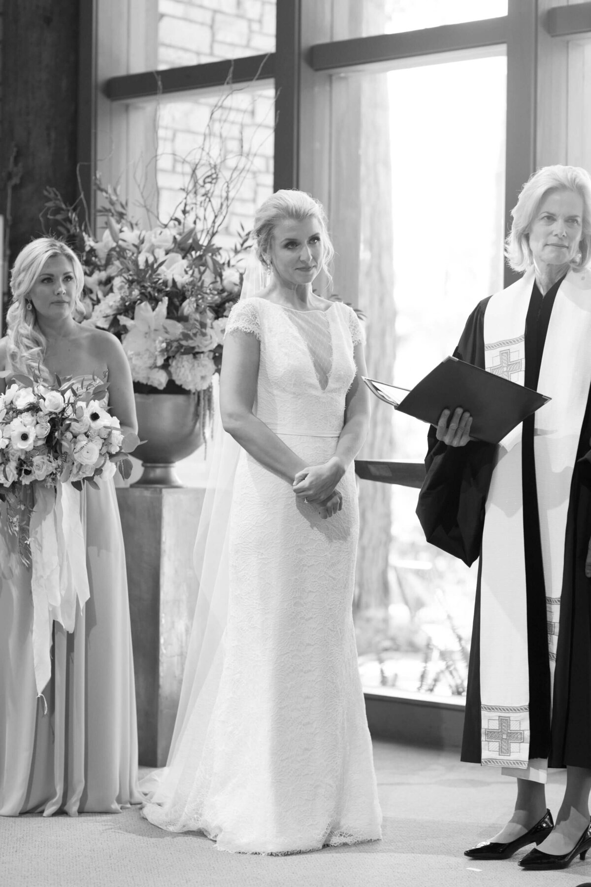 Bride stands tall as female officiator lays out the wedding roles and duties.