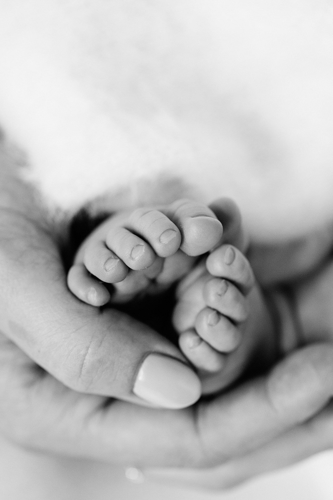 mother holding newborn feet