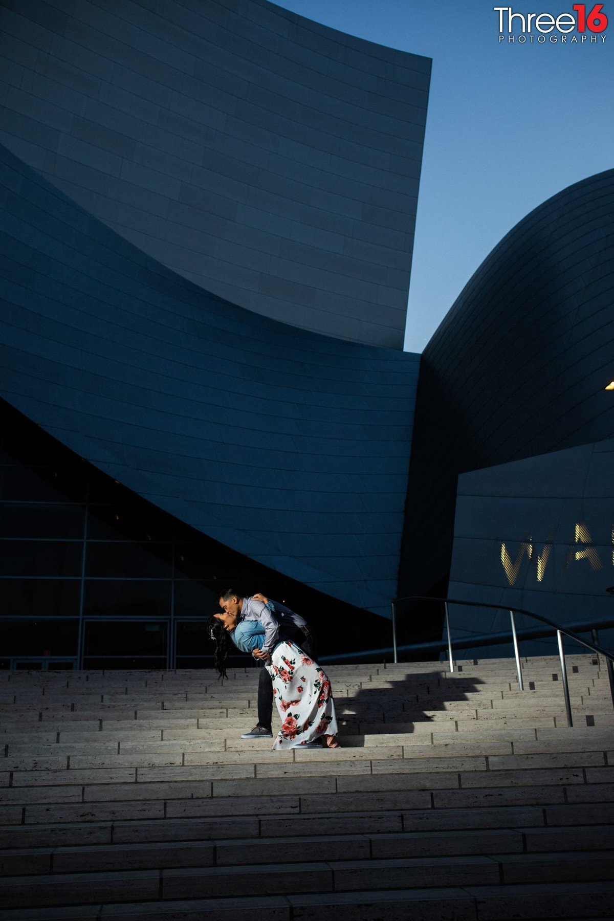 Groom to be dips and kisses his Bride during an evening engagement session at the Walt Disney Concert Hall in Los Angeles
