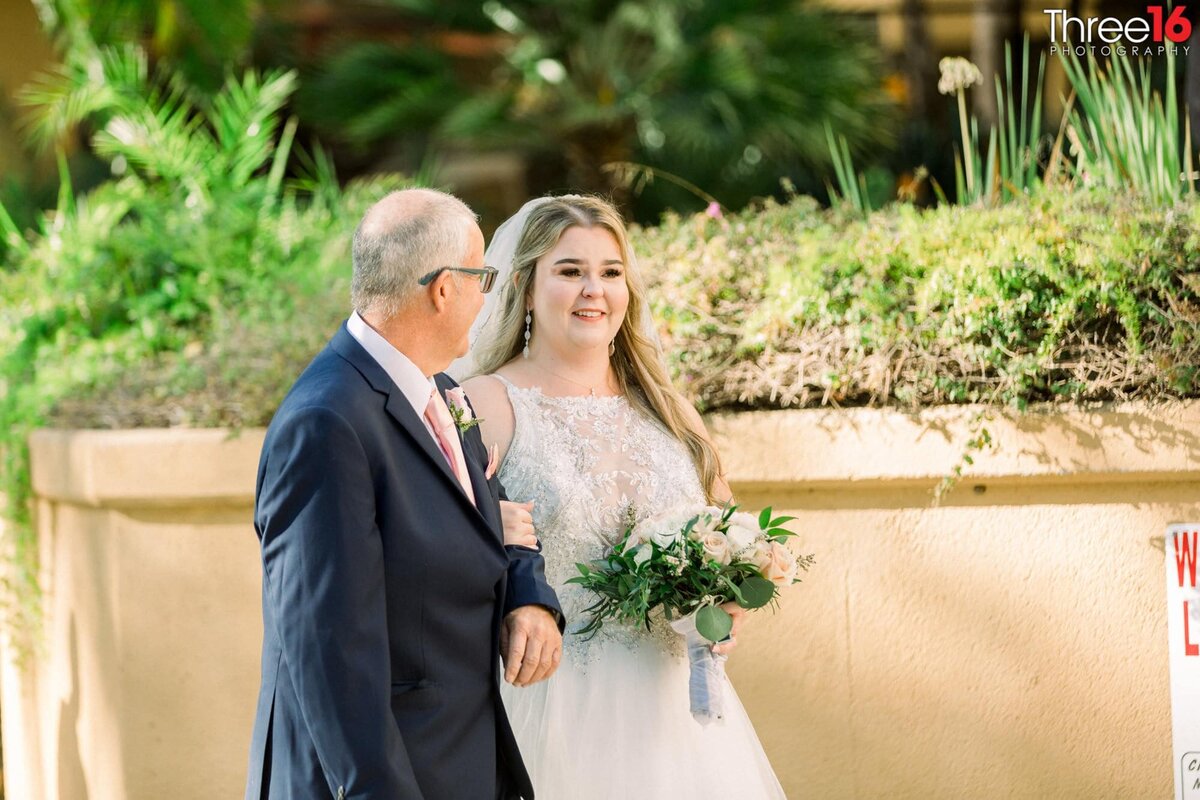 Bride being escorted to the aisle by her father
