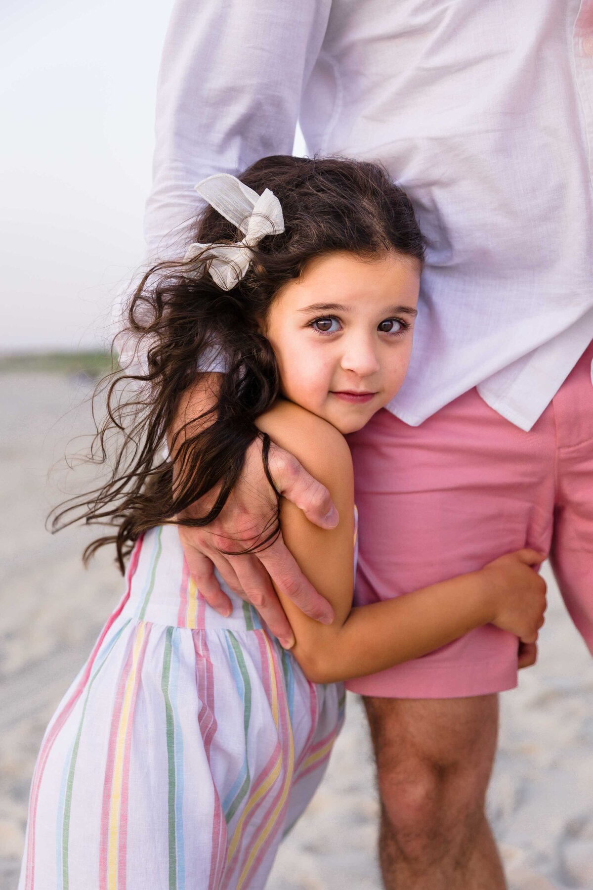 daughter hugging dads legs long island beach photography