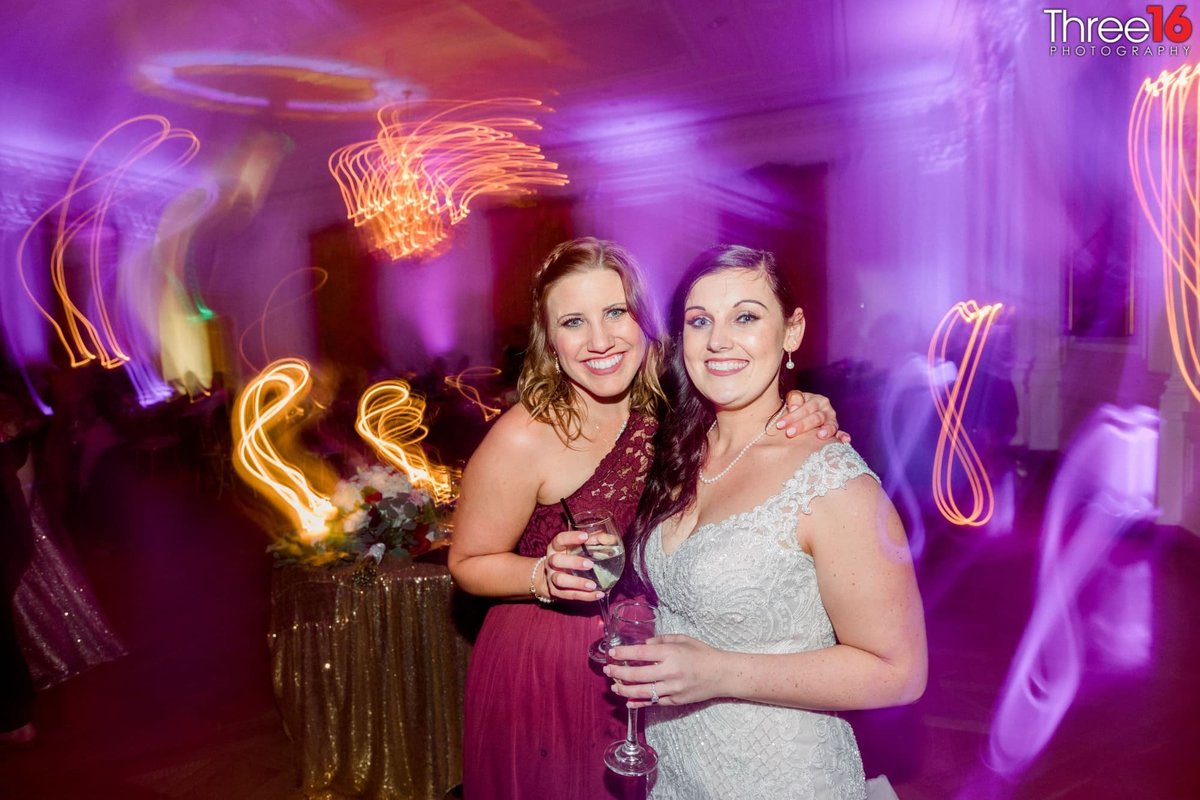 Bride and Bridesmaid are all smiles at the reception