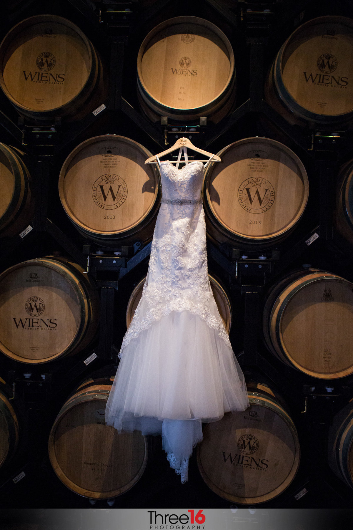 Wedding Dress hangs from Wine Barrels