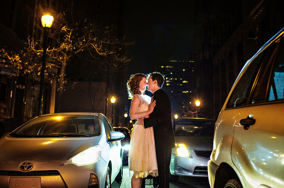A wedding couple kiss in the middle of Walnut Street outside of Stotesbury Mansion.