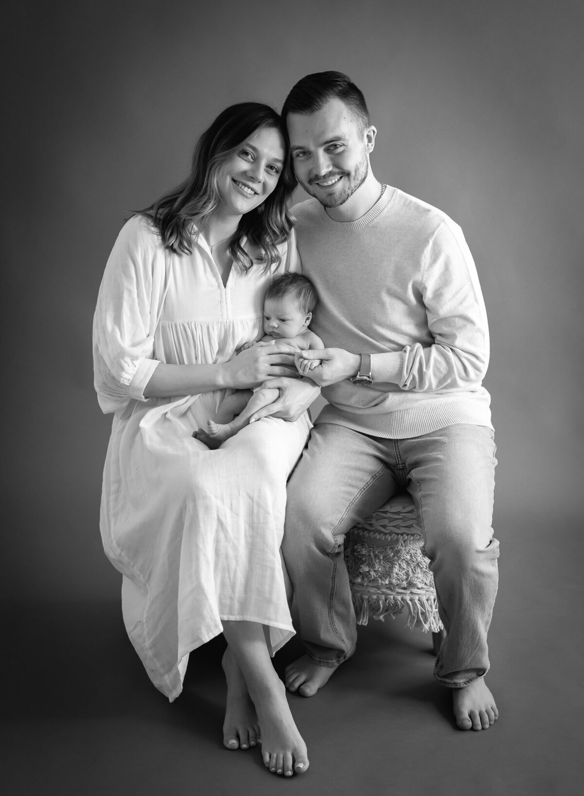 beautiful couple in black & white studio portrait with newborn