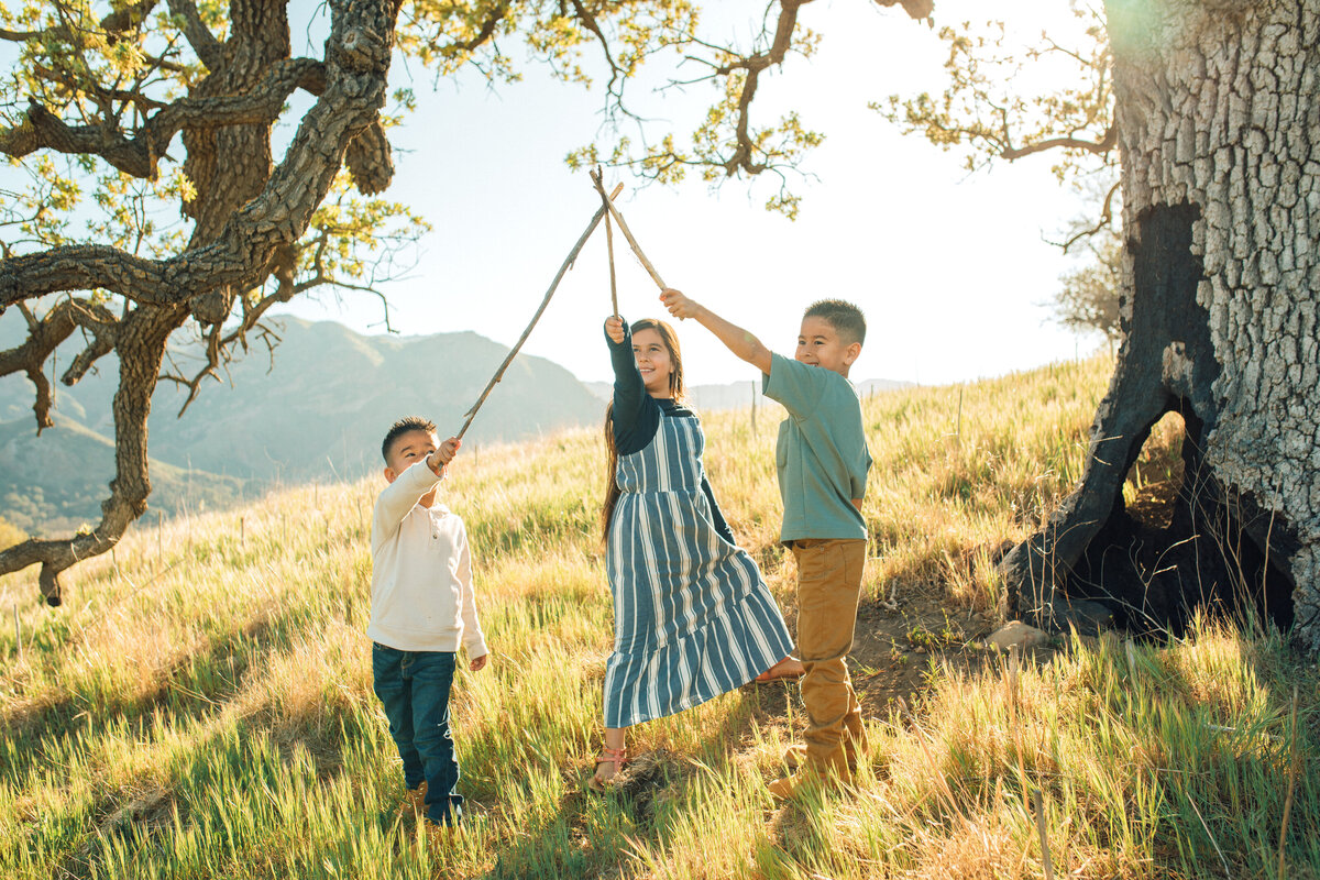 Family Portrait Photo Of Three Siblings Raising Pieces Of Woods Los Angeles
