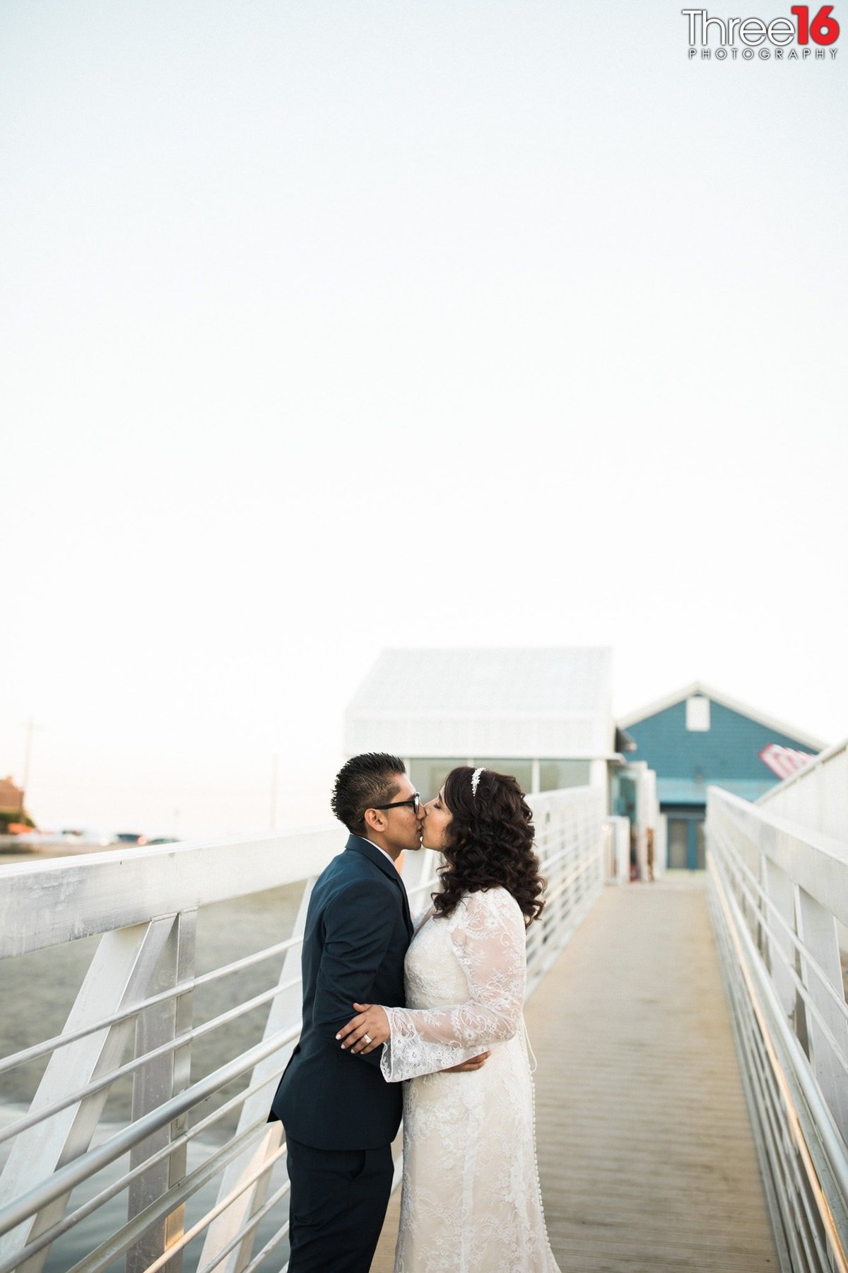 Bride and Groom stop on the boat ramp to share a kiss
