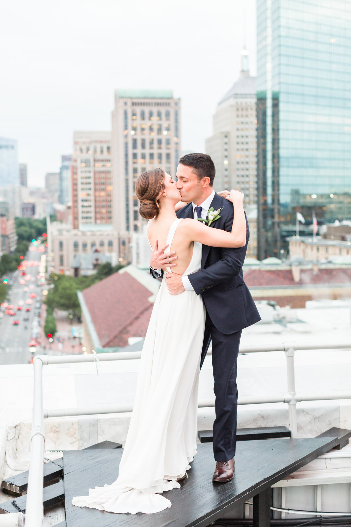 Bride and groom kissing on rooftop at the Lenox Hotel