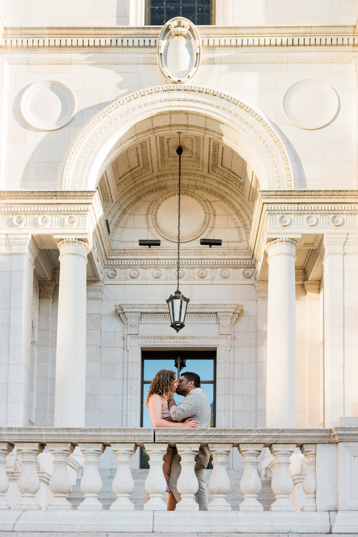 Multicultural couple kissing under archway in St. Paul, MN
