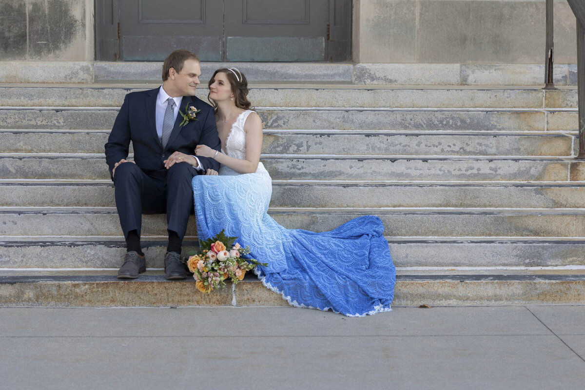 Bride and groom sit on steps
