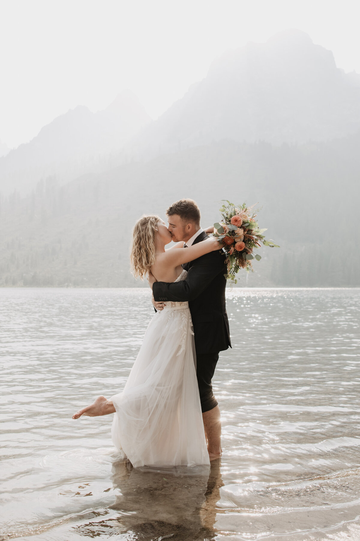 Jackson Hole Photographers capture bride and groom in water during bridal portraits