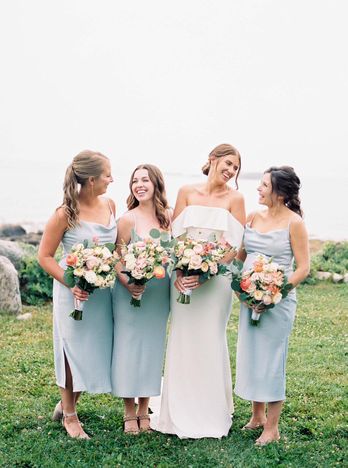 Bride with bridesmaids wearing pale blue dresses at Oceanstone Resort Wedding in Nova Scotia