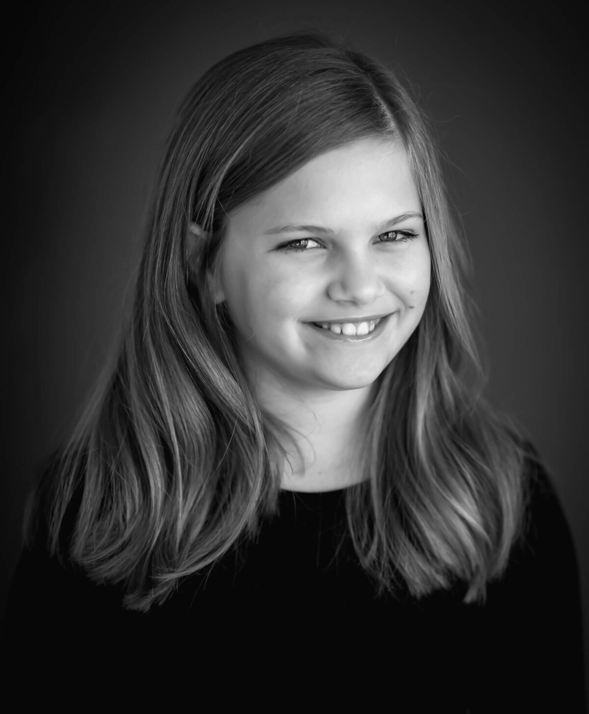 black and white studio portrait of 10 year old looking mischievous