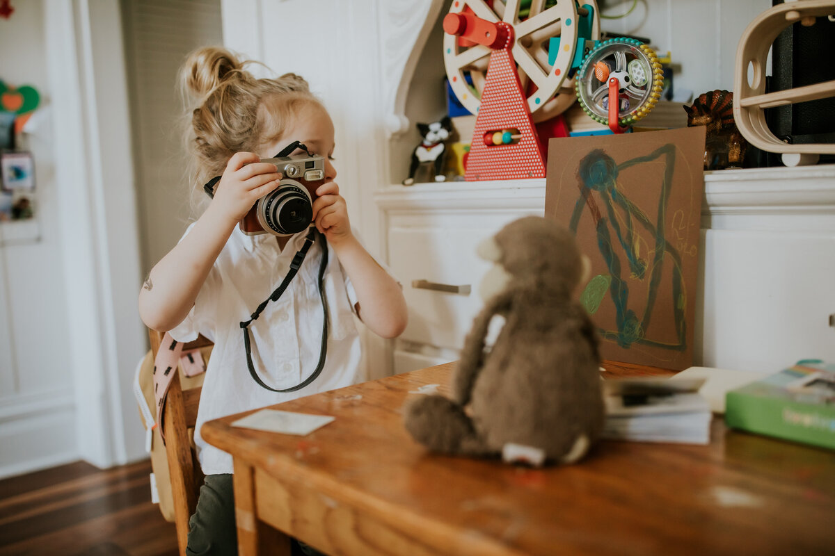 San Francisco child takes picture of stuffy at in home family photography session