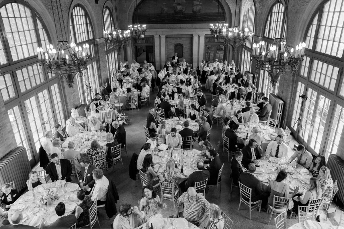 Guests enjoying dinner at a wedding reception at Columbus Park Refectory for a Luxury Chicago Outdoor Historic Wedding Venue.